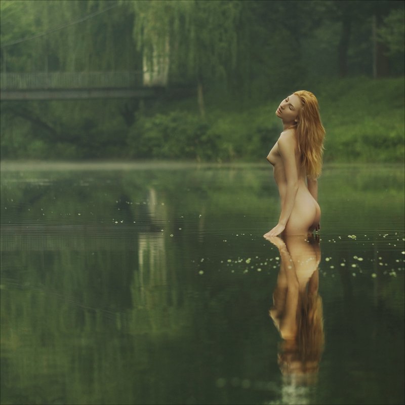 Красивая голая девушка у воды
