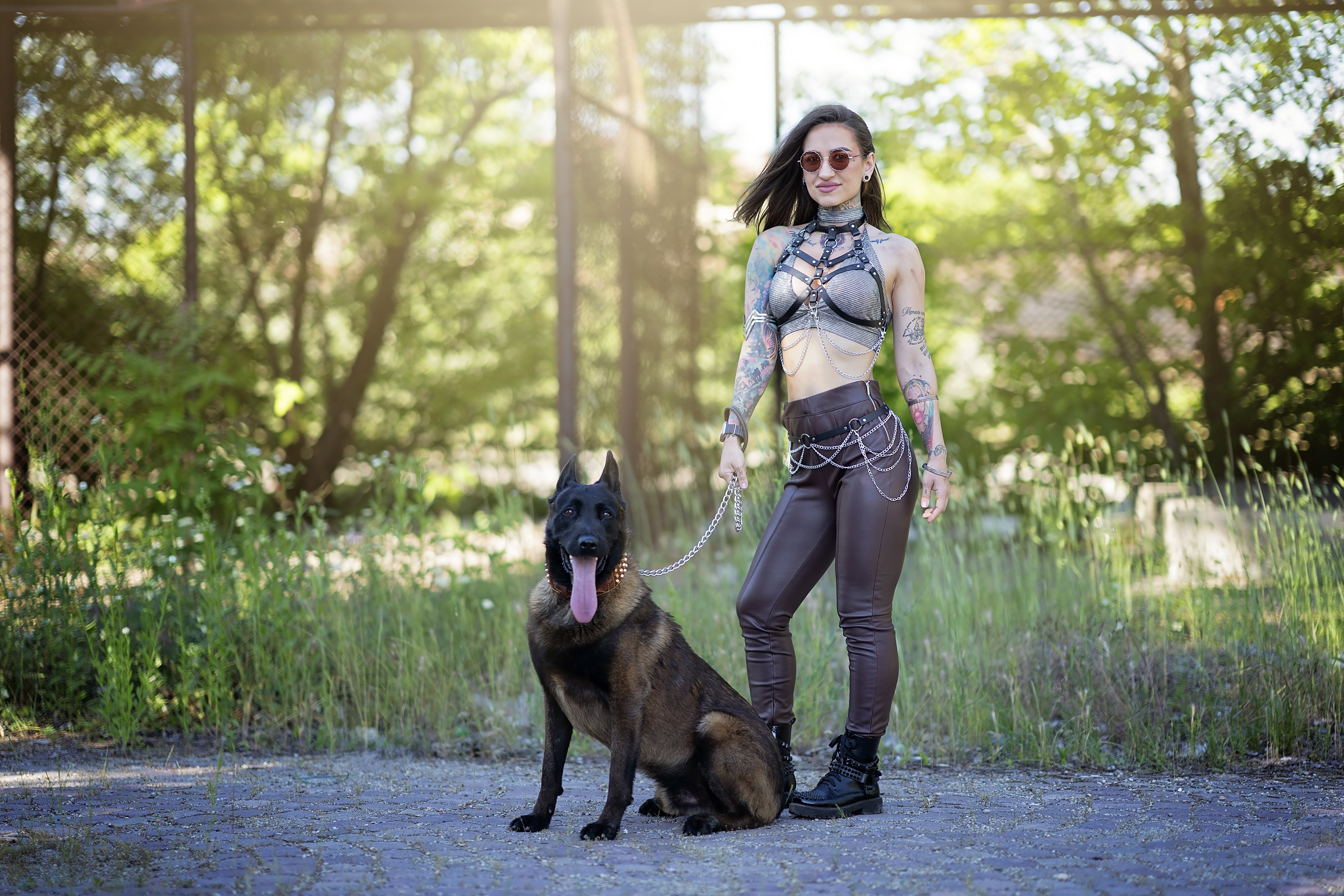 tattooed woman, Belgian Malinois, chains, alternative style, urban fashion, attitude, female power, nature-city contrast, sunlight, dominance, portrait photography, gothic style, urban forest, edgy look, outdoor fashion, Bogdan Negoita