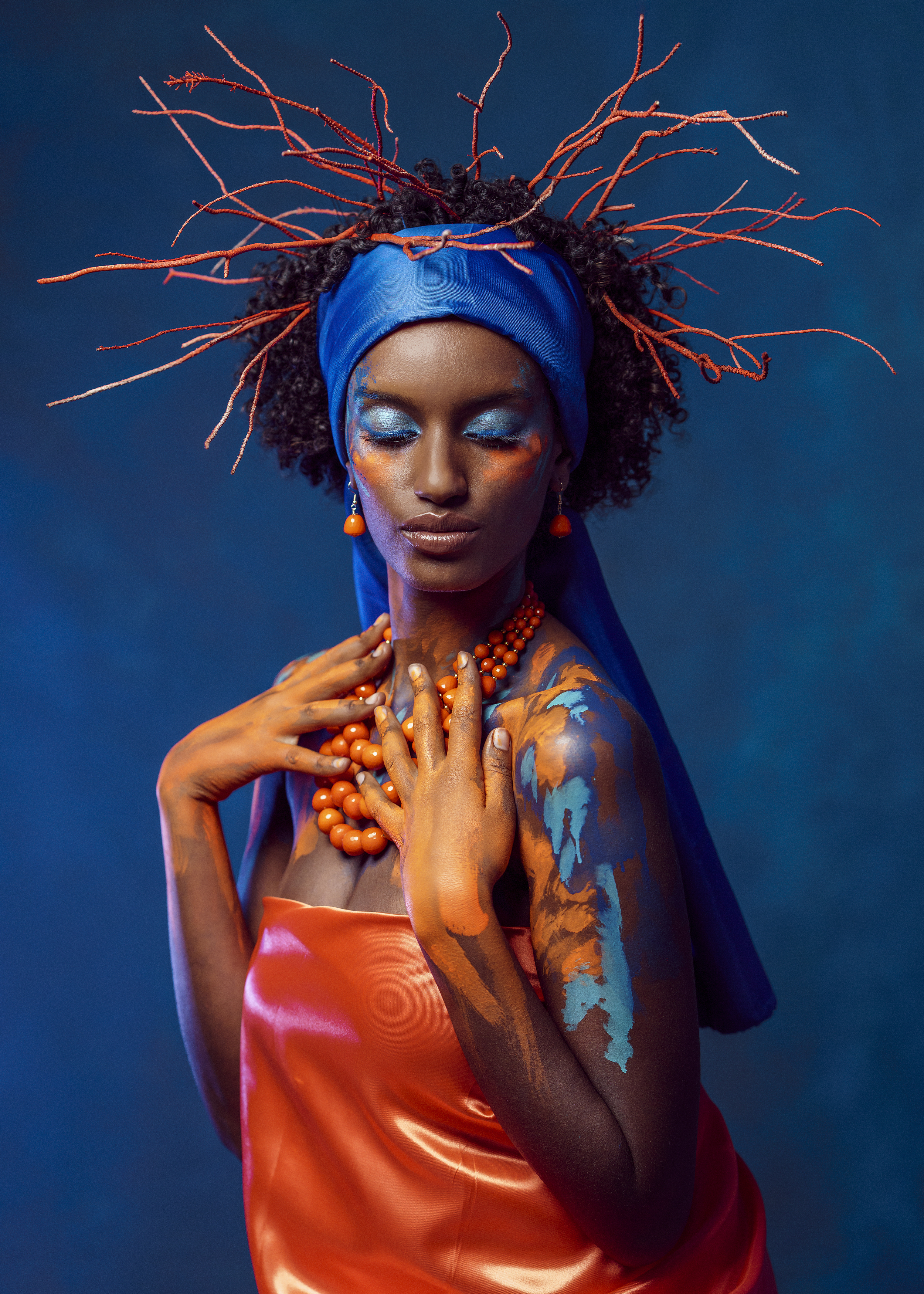 african beauty, amber accents, blue headscarf, body art, bold colors, contrasting light, creative makeup, curly hair, dark skin, delicate pose, earrings, exotic elegance, expressive hands, female portrait, fine art, necklace, side view, young woman, Alex Tsarfin