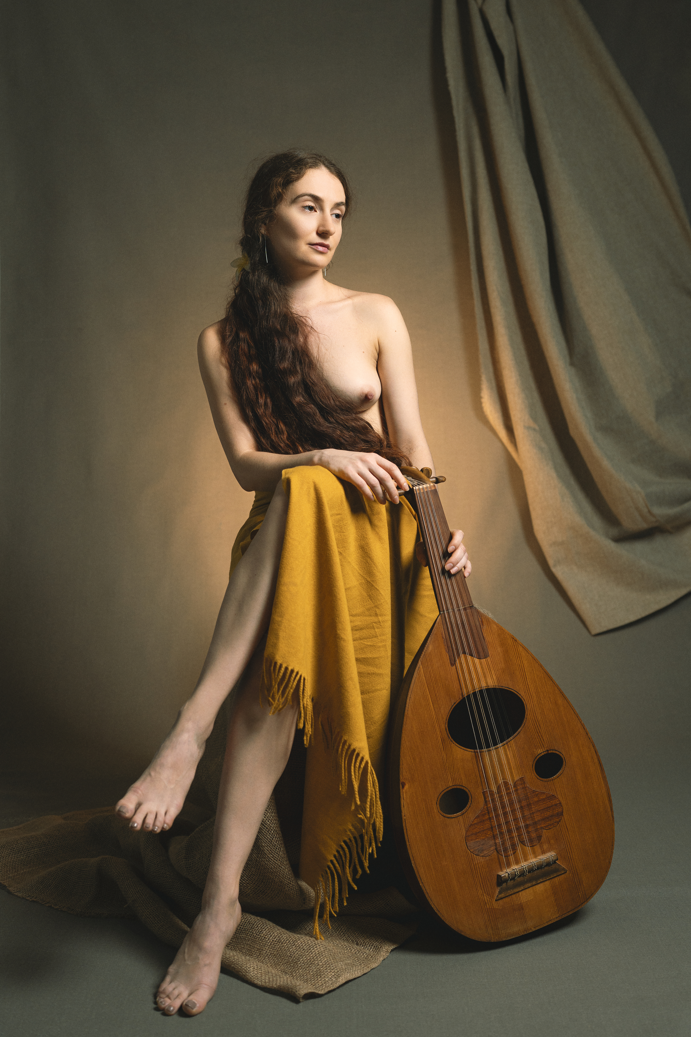 artistic nude, classical pose, draped fabric, earthy textures, elegant composition, golden cloth, intimate atmosphere, lute instrument, minimal backdrop, muted palette, natural grace, renaissance influence, serene mood, soft lighting, warm tones, Alex Tsarfin