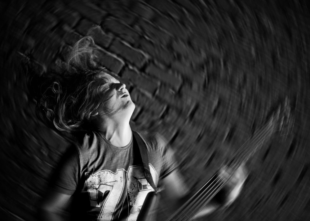 music, radial, play, bass, guitar, black and white, long hair, wall, euphoria, 50mm, natural light, Mike Danilov