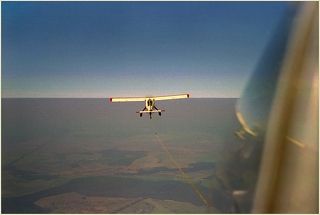 На привязи. Высота ок.1300. Чёткая линия от крыльев - это не горизонт, это слой инверсии, очень выраженный в безоблачную погоду.  Самолёт - Вильга 35А.