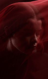 Фотография девушки в студии с красной вуалью