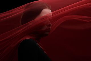 Фотография девушки в студии с красной вуалью