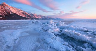 Солнце наконец поднялось над горизонтом окрасив сопки и выступающие льдины торосов в розовый цвет.