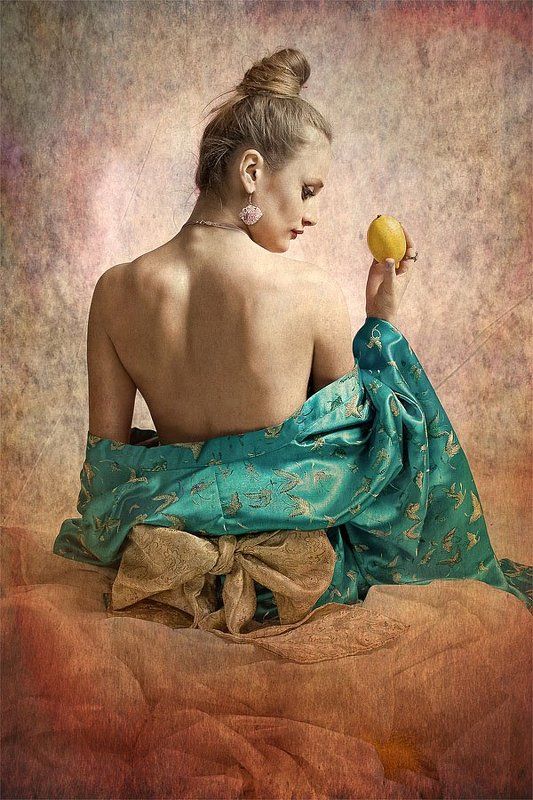 Девушка сидящая на коленях с лимоном в правой рукеphoto preview